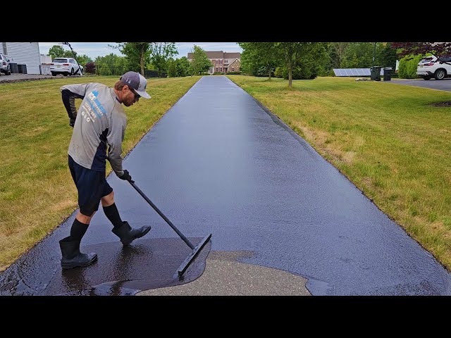 Fresh sealcoat being applied to a residential driveway