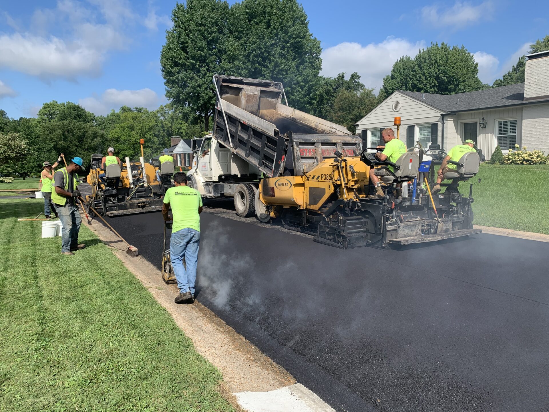GDL paving crew laying fresh hot-mix asphalt on a residential driveway